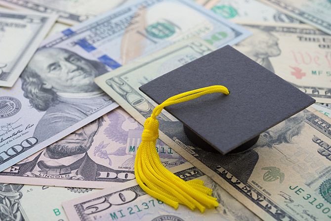 Small graduation cap on a pile of money
