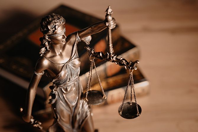 Photo of a Lady Liberty statuette next to legal books