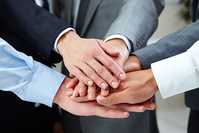Why Join Nebraska Society of CPAs? A close-up of diverse hands stacked together, symbolizing teamwork and unity. People wear formal suits, conveying a professional and collaborative tone.
