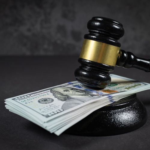 State Tax Briefing: Critical Legal Criteria to Address for Incentive Projects; A judge's gavel is placed on a stack of U.S. hundred-dollar bills against a dark, textured background, symbolizing justice and financial decisions.
